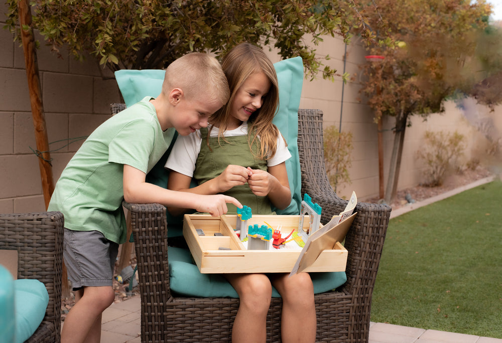 Two children building together, each on their own TRA tray